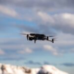 Een thermische drone inspecteert nutsinfrastructuur van bovenaf, met zichtbare warmtemetingen.